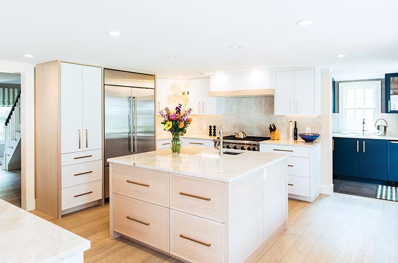 The renovated kitchen now features an oversized island and open corner shelves.