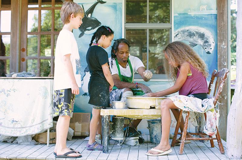 Lenston Daugherty teaches campers how to use the pottery wheel.