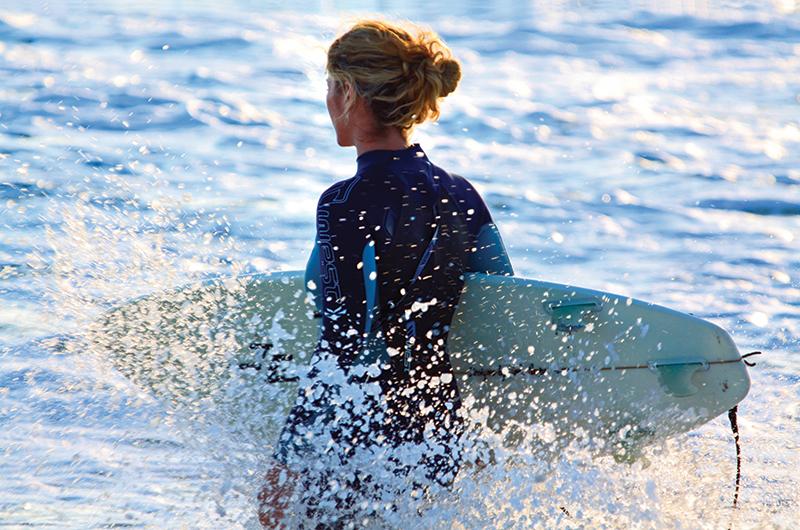 Griffin Hughes, heads into the waves with board in hand.