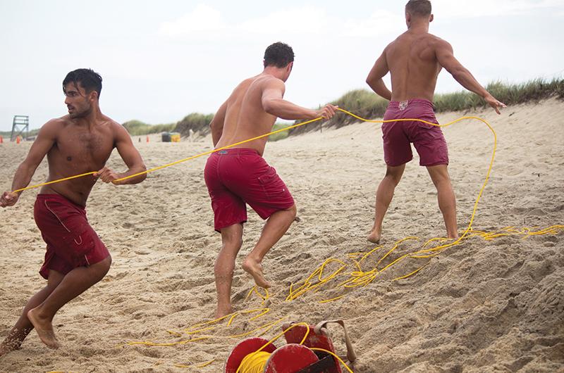 Alex Vasiliadis, John Norton, and Austin Reid hold the line during a rip current training exercise.
