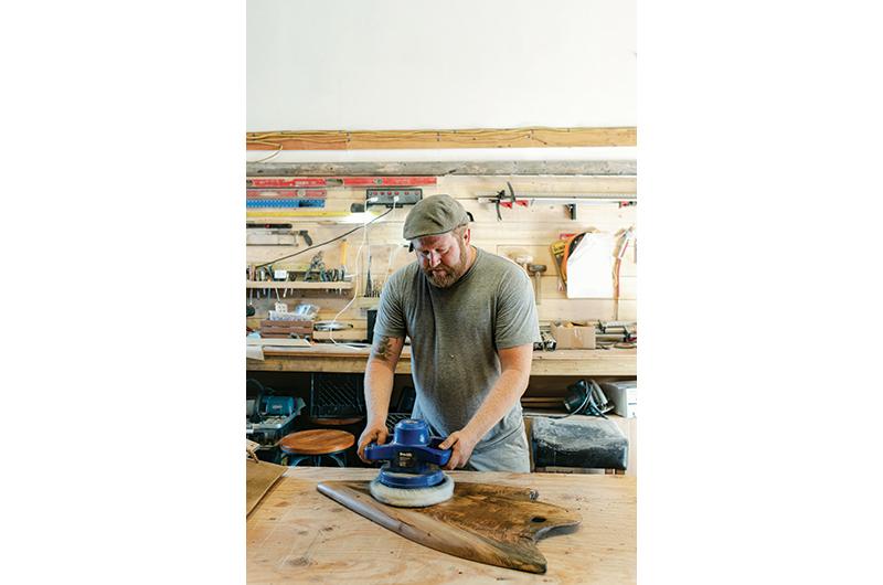 Tucker buffs the finish of a large sycamore “spear point” cutting board.