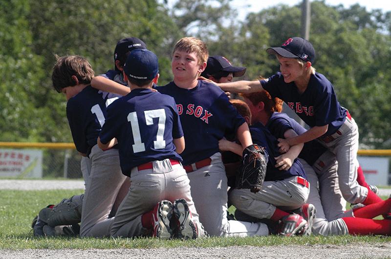 It’s a mob scene at Veira Park after Red Sox pitcher Jake Howell (center) strikes out the last batter of the 2013 Little League Majors championship to seal an 8-2 victory over the Tigers. Below: Tigers catcher Hunter Cleary tags Nick Cranston of the Red Sox.