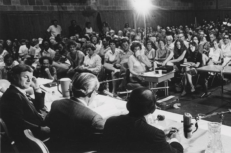 Senator Edward M. Kennedy and a Senate subcommittee meet with Islanders at the Tisbury School to discuss the merits of the Nantucket Sound Islands Trust bill, July 1973.