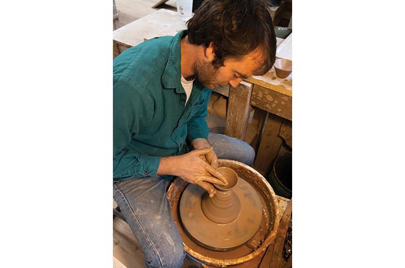 Thanhauser at the potter’s wheel inside his studio, which was once used as a boatbuilding workshop.