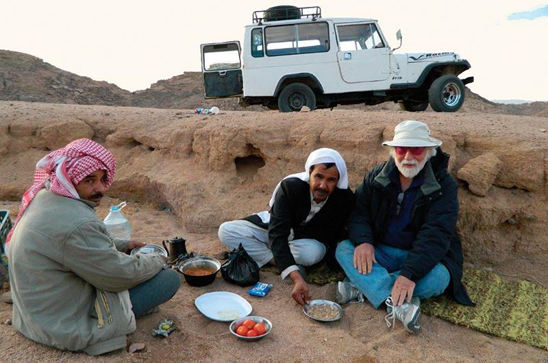 Father Nagle of Oak Bluffs, right, stops along a road in the mountains of Egypt for lunch with his driver and a friend.