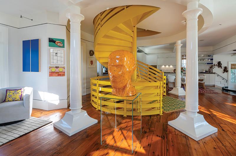 A sculpture and circular staircase in shades of yellow are a focal point of the first floor.