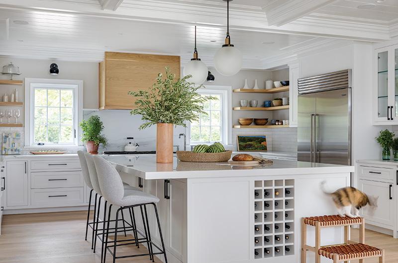 The kitchen's oversized central workspace offers additional seating and extra storage space with cabinets and a built-in wine rack.