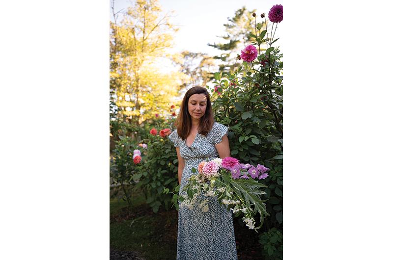 Hall gathers flowers and greenery to create a bouquet at her Long Road Flower Farm.
