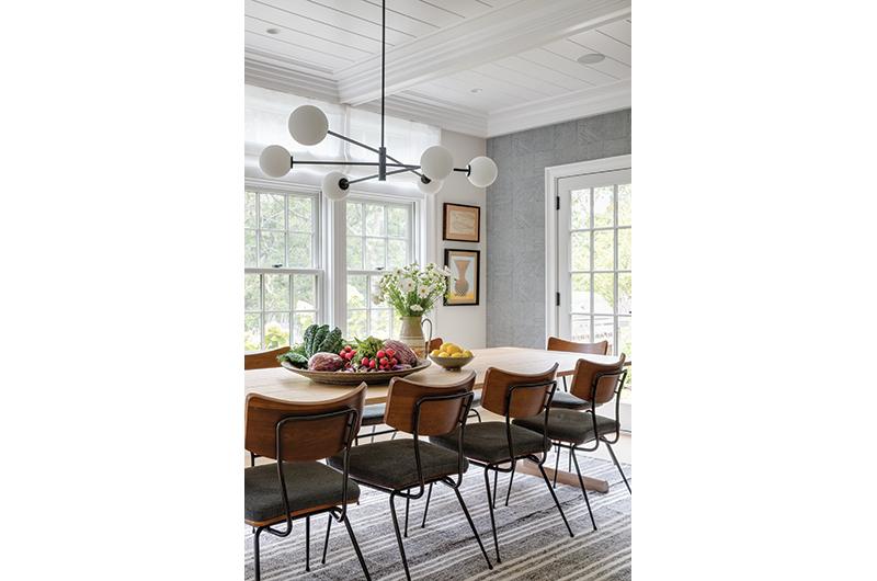 An accent wall helps define the dining area, which features a ten-person handmade natural oak table and views of Jacob’s Pond.